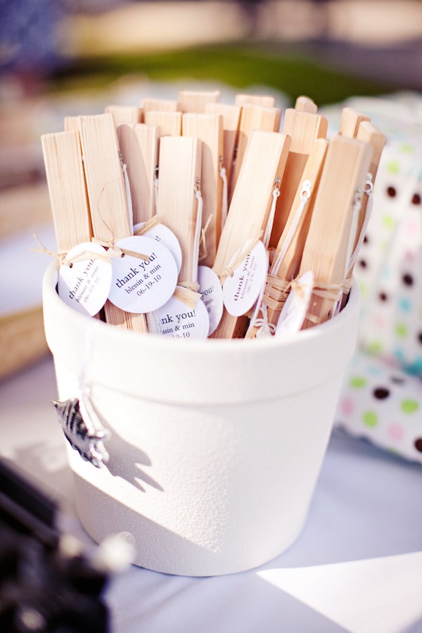 Wedding favors - Folded fans with thank you card attached on display in a white porcelin pot - photo by San Francisco based wedding photographer Meg Perotti